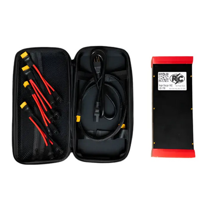 Charging cable set with multiple connectors and adapter in a carrying case alongside a battery pack for the Roger Charger V4SC electric unicycle.